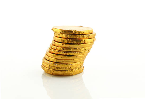 Stack of chocolate sweets wrapped in foil. Coins isolated on white background