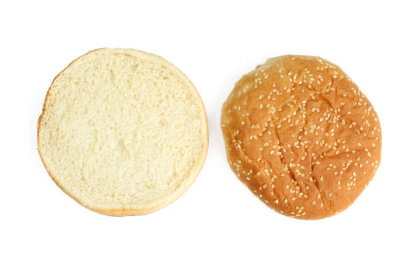 istock Sliced burger bun with sesame seeds above. Isolated on white background 1407118907