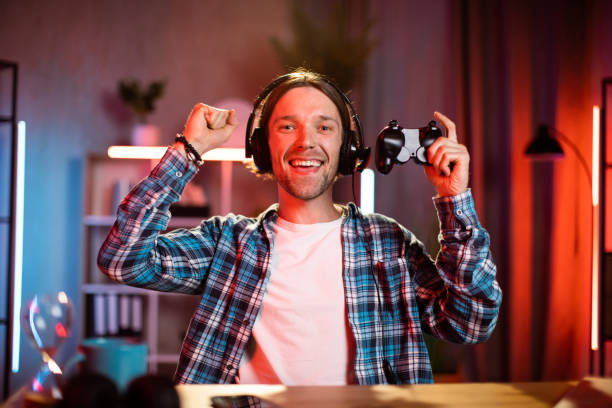 istock Overjoyed young man in headset screaming and gesturing while celebrating victory in video games. 1407121387