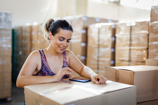 Smiling young woman working in warehouse