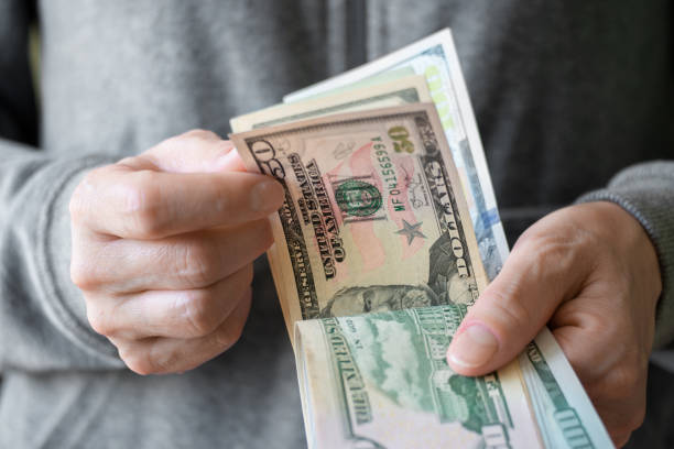istock White female count US dollar bills bills in her hands 1407126389