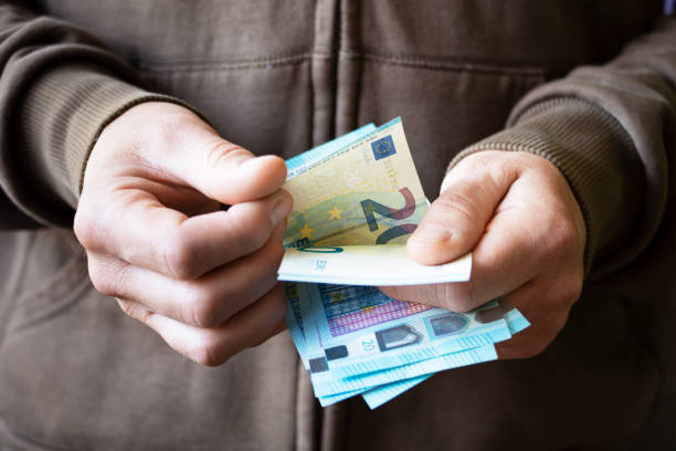 hombre blanco cuenta billetes de euro en sus manos - ukraine hryvnia currency paper currency fotografías e imágenes de stock