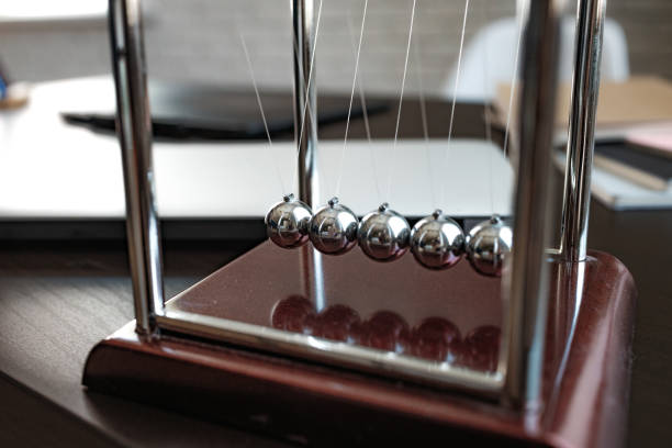 istock Newton's cradle balls on the wooden table in office 1407129775