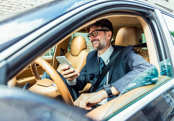 istock Cheerful senior man using his smartphone in the car 1407130663