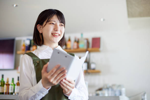 Young Japanese woman working at cafe Young Japanese woman working at cafe retail clerk photos stock pictures, royalty-free photos & images