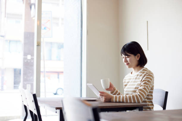 istock Young Japanese woman relaxing at cafe 1407130955