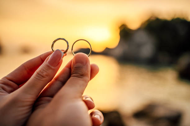 istock Couple holding their wedding ring on the beach 1407133610