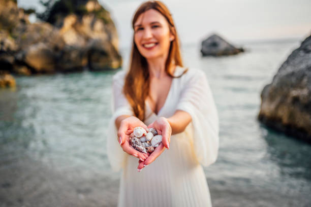 istock Woman holding seashells from the beach 1407133816