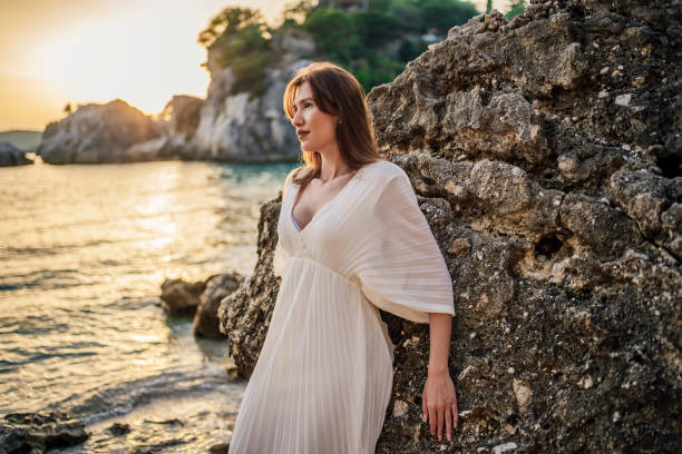 istock Beautiful woman on the rocky beach 1407134721