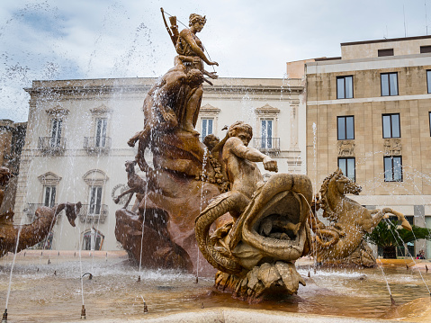 The Fountain of Diana (Fontana di Diana) is in the center of Piazza Archimede in Syracuse on the east coast of Sicily. It is also known as the Fountain of Artemis, as the original Greek name