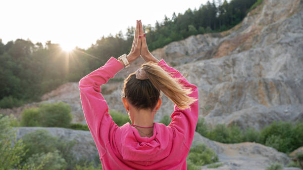 Young woman practicing mindfulness with her palms joined above her head stock photo