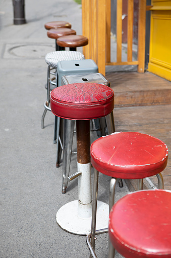 Different styles of cafe stools on the pavement in the Montmartre district of Paris