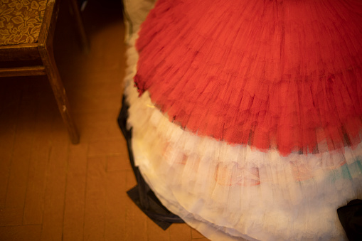 Ballet tutu in costume. Red dress for ballerina. Details of costume room in theater.