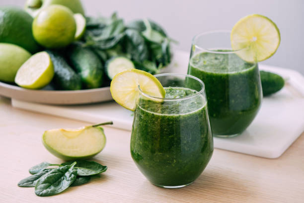 istock Green vegetable fruit smoothie in various glasses light background, Vegetarianism healthy lifestyle 1407139713
