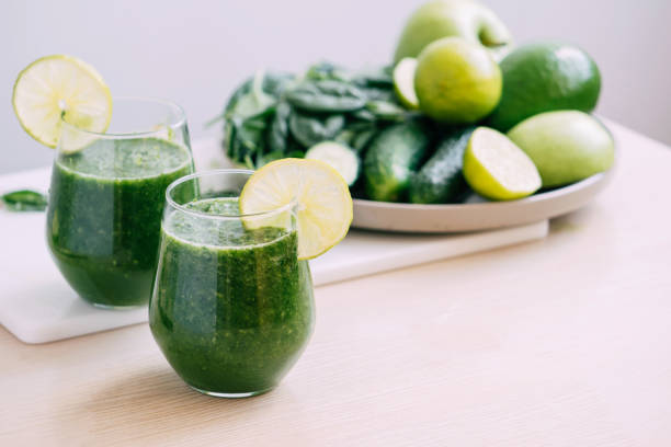 istock Green vegetable fruit smoothie in various glasses light background, Vegetarianism healthy lifestyle 1407139729