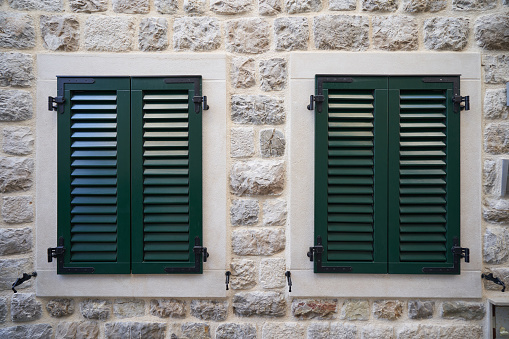 Green plastic shutters on windows, home improvement concept.