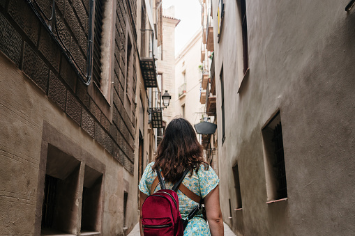 A young tourist woman in a narrow street in Barcelona's old town area