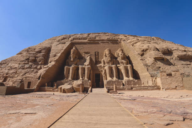 The main view of an Entrance to the Great Temple at Abu Simbel with Ancient Colossal statues of Ramesses II The main view of an Entrance to the Great Temple at Abu Simbel with Ancient Colossal statues of Ramesses II, seated on a throne and wearing the double crown of Upper and Lower Egypt temple of luxor hypostyle hall stock pictures, royalty-free photos & images