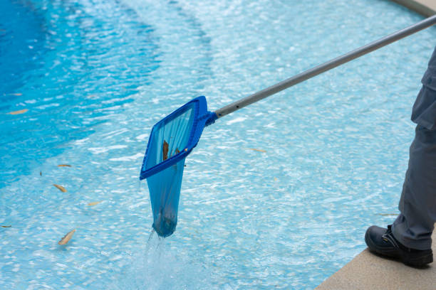 istock Close Up Workers are using a grid to collect leaves and rubbish that have fallen into the hotel swimming pool to keep the pool ready for use. 1407144616