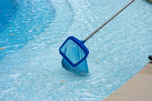 istock Close Up Workers are using a grid to collect leaves and rubbish that have fallen into the hotel swimming pool to keep the pool ready for use. 1407144624