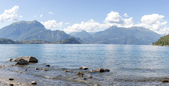 Panoramic view of Como Lake with mountains and clouds in background. Panoramic composition.