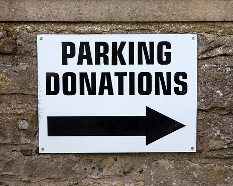 Close-up of a Parking Donations sign in a car park in the market town of Leyburn in North Yorkshire, UK.