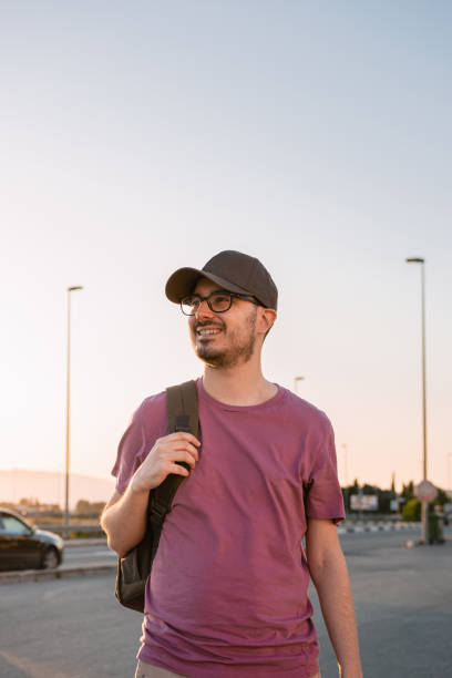 istock Man with a cap and a backpack smiles on the street 1407149193
