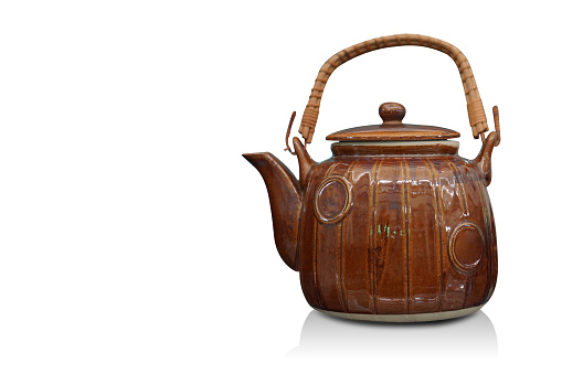ancient brown ceramic kettle and handle made of rattan on a white background, object, vintage, decor, fashion, copy space