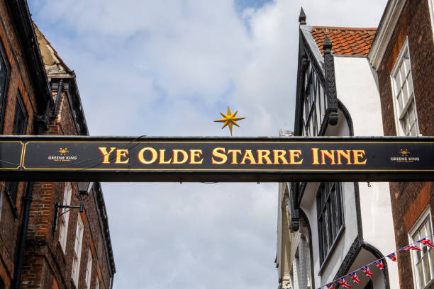 York, UK - June 6th 2022: A sign above the street on Stonegate in York, UK, marking the location of Ye Olde Starre Inne public house.