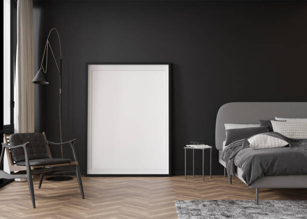 istock Empty vertical picture frame standing on parquet floor in modern bedroom. Mock up interior in contemporary style. Free, copy space for your picture, poster. Black wall, bed, armchair. 3D rendering. 1407156325