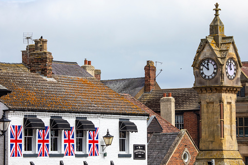 Thirsk, UK - June 7th 2022: View of the Clock Tower, or Town Clock, in the pretty market town of Thirsk in North Yorkshire, UK.