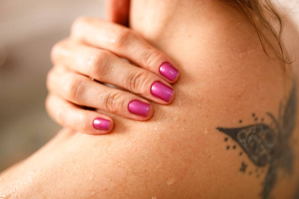 Woman with hand over her shoulder relaxing spa day at home back shoulder tattoos for women pictures stock pictures, royalty-free photos & images