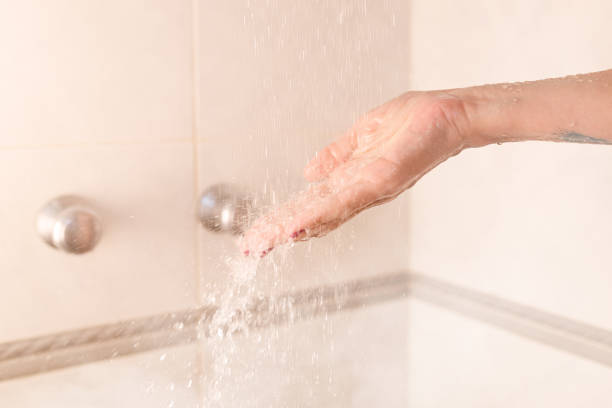 istock Person checking water temperature in the shower 1407157316
