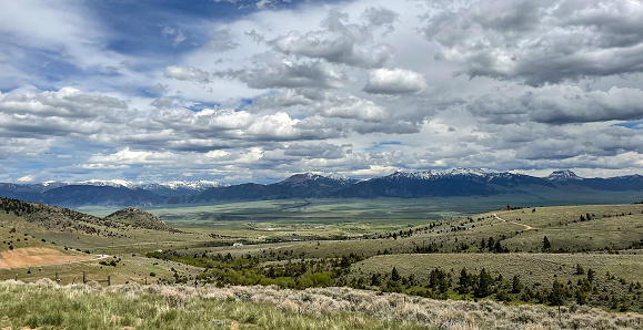 This valley view is from the hills above Ennis Montana on the road to Virginia city. The snow capped mountains can be seen in the distance