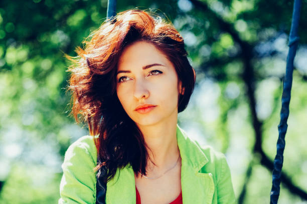 Young beautiful red haired woman looking into the camera. Natural happiness, joy and harmony