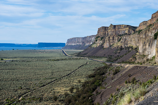 Scenic desert road running along basalt rock formations near Grand Coulee in Eastern Washington state, USA