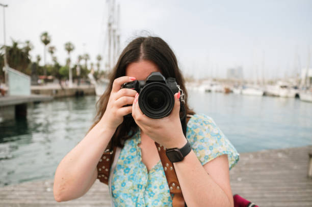 istock Young woman taking a picture with a DSLR camera 1407159355