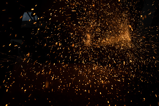 Lights in dark. Sparks from sawing metal. Industrial background. Lots of screeds on dark background.