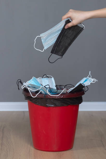 istock Throw a black medical protective mask into a red trash can 1407161343