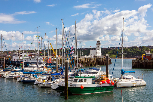 Scarborough, UK - June 8th 2022: Fishing boats and vessels docked in the harbour at Scarborough in North Yorkshire, UK.