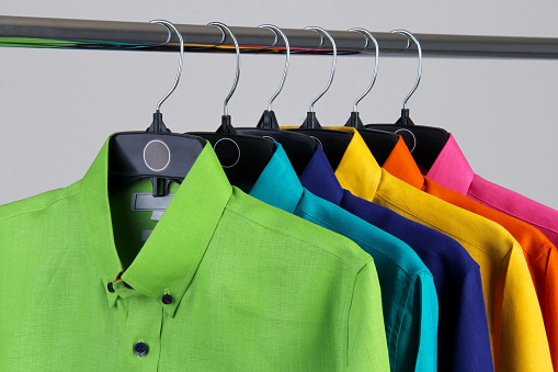 shirts of vibrant colors on aluminum rack. concept clothing store. shirts for men, shirts for summer