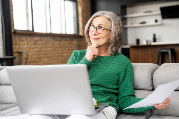 istock Beautiful senior woman using laptop at home 1407163027