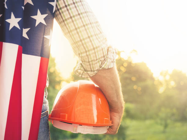 istock Attractive man in work clothes, holding American Flag 1407163047