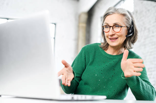 istock Senior gray-haired female employee in a headset 1407163054