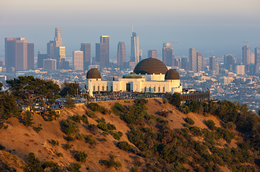Griffith Observatory at sunset with the Los Angeles skyline in the distance