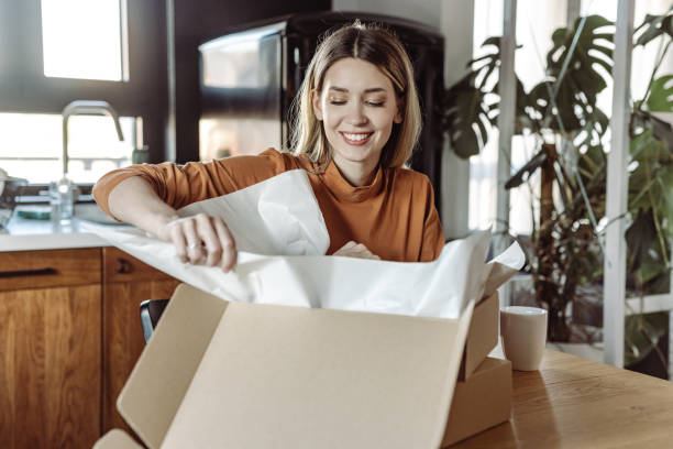 Satisfied young woman opening a postal delivery stock photo