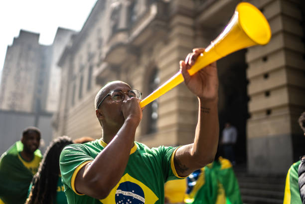 giovane che celebra una partita di calcio all'aperto - vuvuzela foto e immagini stock