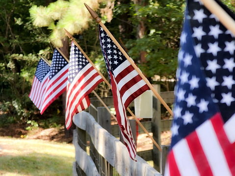 American Flag - Small flags on a weather worn wooden fence.