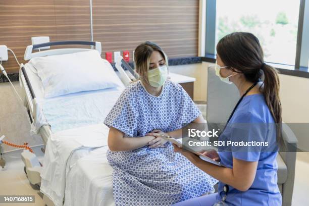 Female Patient Grabs Her Stomach Stock Photo - Download Image Now - Miscarriage, Protective Face Mask, Nurse