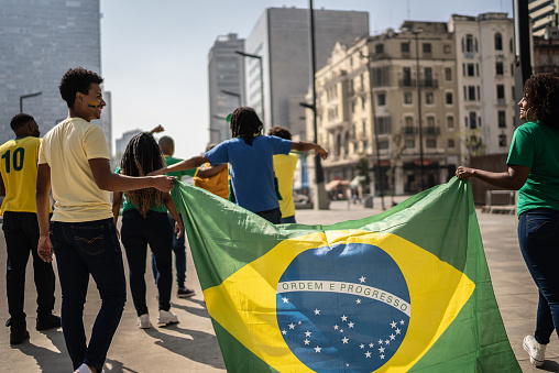 Brazilian fans with a brazil flag outdoors